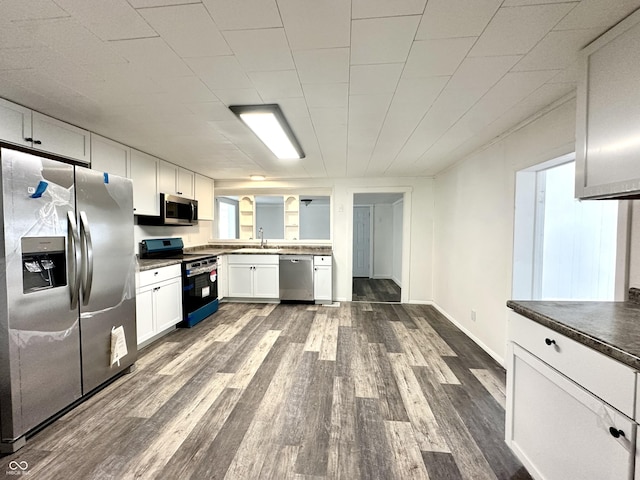 106 S Hancock St, Waynetown, IN 47990 - kitchen with stainless steel appliances, dark wood-type flooring, dark countertops, white cabinetry, and a sink