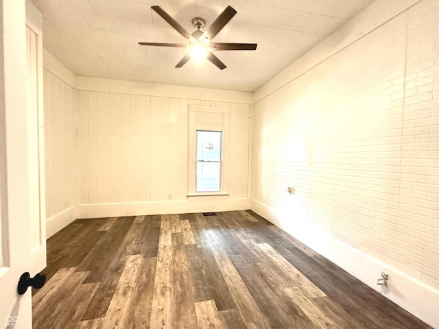 106 S Hancock St, Waynetown, IN 47990 - empty room featuring dark wood-type flooring, ceiling fan, brick wall, and baseboards
