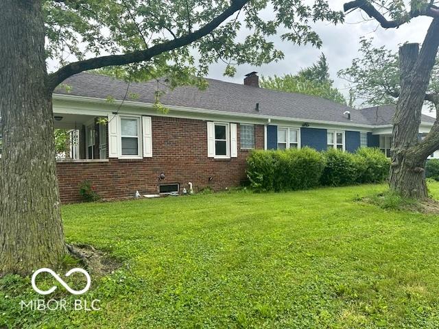 5147 E 16th St, Indianapolis, IN 46218 - rear view of property with brick siding, a lawn, and a chimney