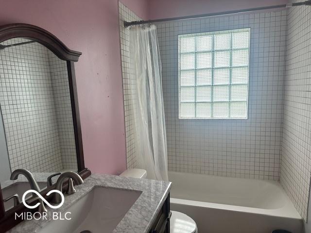 5147 E 16th St, Indianapolis, IN 46218 - bathroom with vanity, shower / bathtub combination with curtain, and toilet