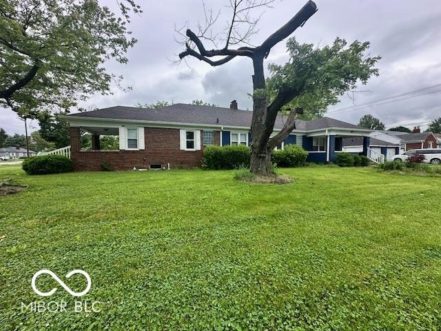 5147 E 16th St, Indianapolis, IN 46218 - rear view of property with a lawn, brick siding, and a chimney