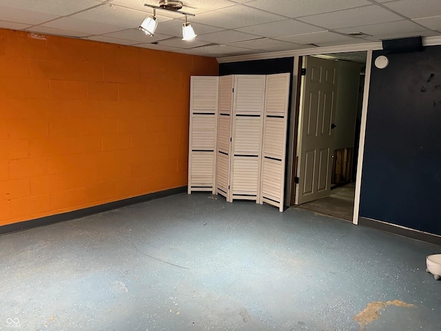 5147 E 16th St, Indianapolis, IN 46218 - empty room with concrete block wall, a paneled ceiling, and baseboards