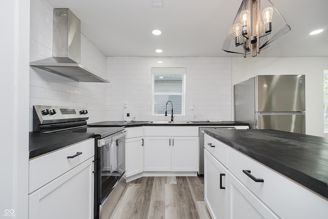 2631 Collier St, Indianapolis, IN 46241 - kitchen with stainless steel appliances, wall chimney exhaust hood, dark countertops, a sink, and a chandelier