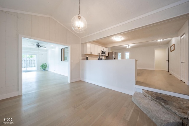 1127 Hickory Ln, New Castle, IN 47362 - unfurnished living room with healthy amount of natural light, light wood-style floors, vaulted ceiling, wood walls, and a chandelier