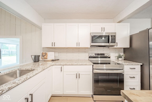 1127 Hickory Ln, New Castle, IN 47362 - kitchen featuring stainless steel appliances, backsplash, white cabinetry, and a sink