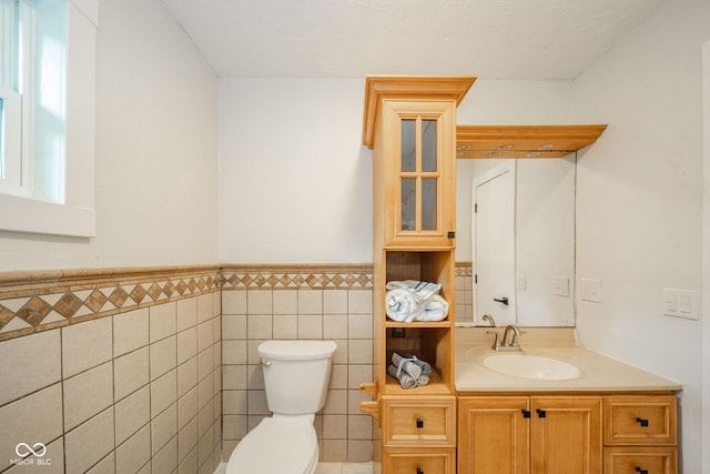 1127 Hickory Ln, New Castle, IN 47362 - bathroom with toilet, vanity, tile walls, and wainscoting
