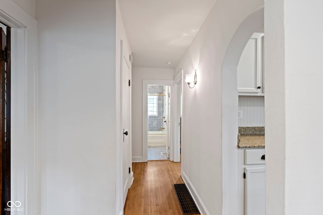 5259 Broadway St, Indianapolis, IN 46220 - corridor featuring arched walkways, light wood-style flooring, and baseboards