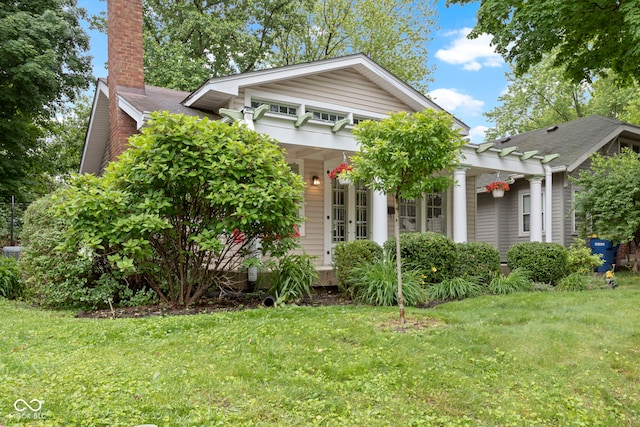 5259 Broadway St, Indianapolis, IN 46220 - view of front facade with a front lawn, a chimney, a pergola, and a shingled roof