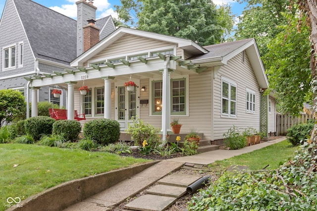 5259 Broadway St, Indianapolis, IN 46220 - view of front of property with a chimney, covered porch, roof with shingles, and a front yard