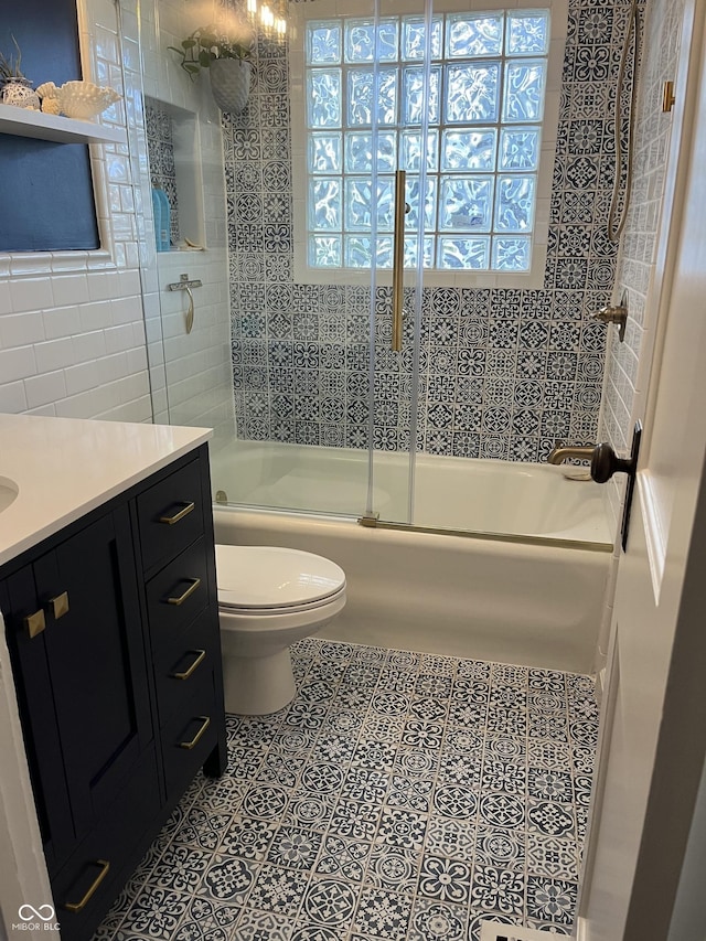 5259 Broadway St, Indianapolis, IN 46220 - full bath with toilet, enclosed tub / shower combo, vanity, tile walls, and tile patterned floors