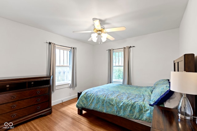 5259 Broadway St, Indianapolis, IN 46220 - bedroom featuring light wood-type flooring, multiple windows, baseboards, and a ceiling fan