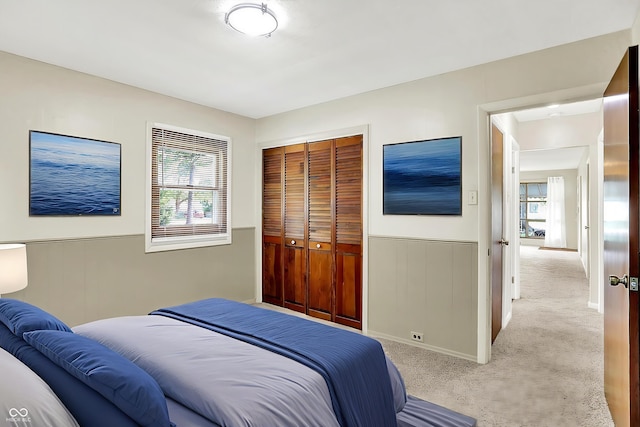 1868 N Hawthorne Ln, Indianapolis, IN 46218 - bedroom with multiple windows, carpet floors, a closet, a wainscoted wall, and baseboards