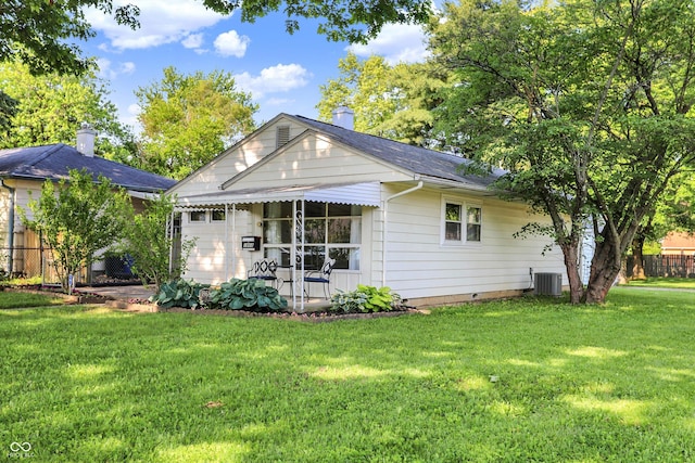 1868 N Hawthorne Ln, Indianapolis, IN 46218 - view of front facade with a front yard, a chimney, central AC, a shingled roof, and crawl space
