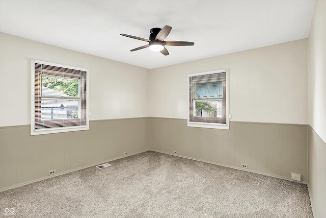 1868 N Hawthorne Ln, Indianapolis, IN 46218 - carpeted spare room with wainscoting and ceiling fan