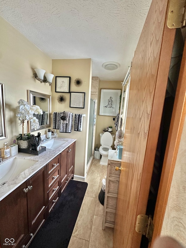 1831 Beckenbauer Ln, Indianapolis, IN 46214 - bathroom with double vanity, toilet, a stall shower, tile patterned flooring, and a textured ceiling