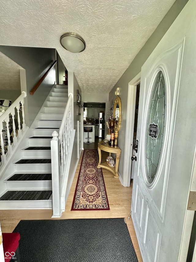 1831 Beckenbauer Ln, Indianapolis, IN 46214 - entrance foyer featuring stairs, wood finished floors, and a textured ceiling