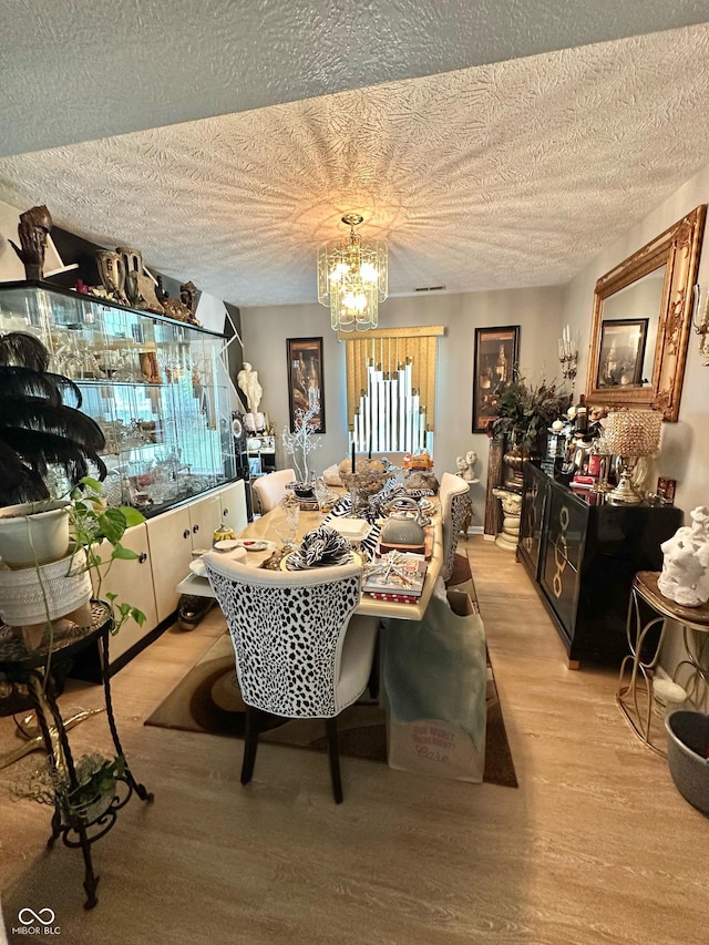 1831 Beckenbauer Ln, Indianapolis, IN 46214 - dining room featuring a chandelier, light wood-style floors, and a textured ceiling