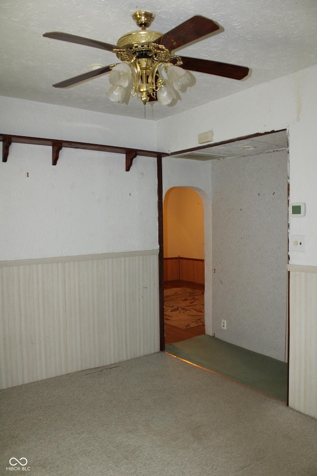 202 S Church St, Brooklyn, IN 46111 - empty room with arched walkways, a wainscoted wall, a ceiling fan, and wooden walls