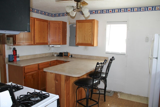 202 S Church St, Brooklyn, IN 46111 - kitchen with white appliances, a peninsula, a ceiling fan, electric panel, and a breakfast bar