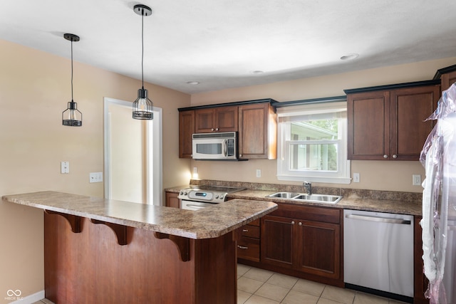 4904 N Tillotson Ave, Muncie, IN 47304 - kitchen with stainless steel appliances, a sink, a kitchen breakfast bar, a peninsula, and light tile patterned floors