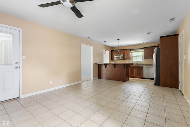 4904 N Tillotson Ave, Muncie, IN 47304 - kitchen with appliances with stainless steel finishes, a kitchen bar, a peninsula, ceiling fan, and open floor plan