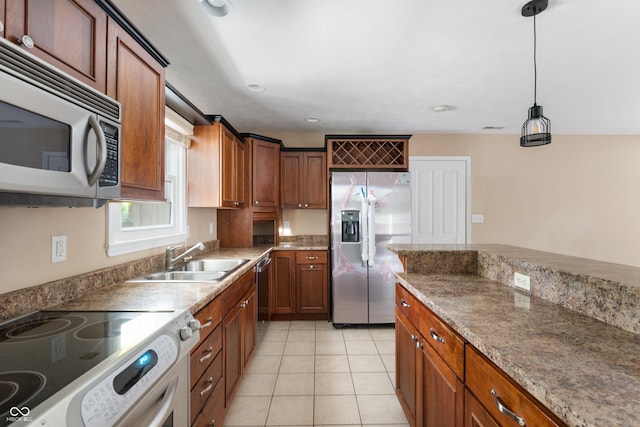 4904 N Tillotson Ave, Muncie, IN 47304 - kitchen with stainless steel appliances, a sink, light tile patterned floors, hanging light fixtures, and brown cabinetry