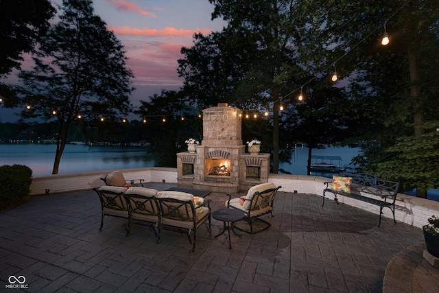 8301 Reef Ct, Indianapolis, IN 46236 - patio terrace at dusk with a patio, an outdoor living space with a fireplace, and a water view