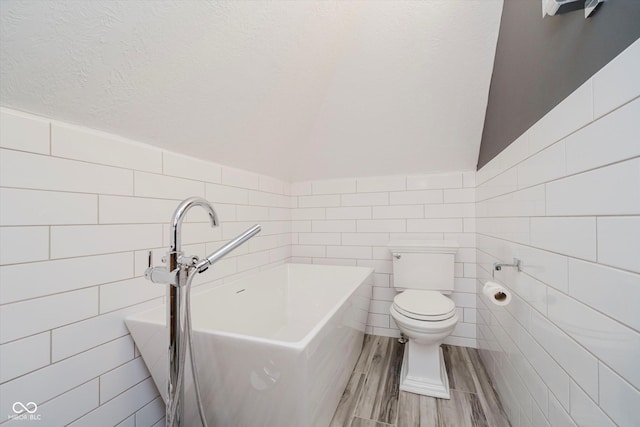 8301 Reef Ct, Indianapolis, IN 46236 - bathroom featuring tile walls, lofted ceiling, and wood finished floors