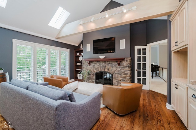 8301 Reef Ct, Indianapolis, IN 46236 - living room featuring a skylight, a stone fireplace, track lighting, vaulted ceiling, and dark wood-style flooring