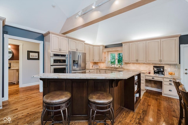 8301 Reef Ct, Indianapolis, IN 46236 - kitchen with stainless steel appliances, a breakfast bar, tasteful backsplash, light stone counters, and a large island