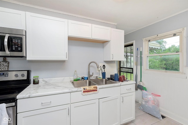 3338 Orchard Ave, Indianapolis, IN 46218 - kitchen with stainless steel appliances, a sink, white cabinetry, light tile patterned floors, and crown molding