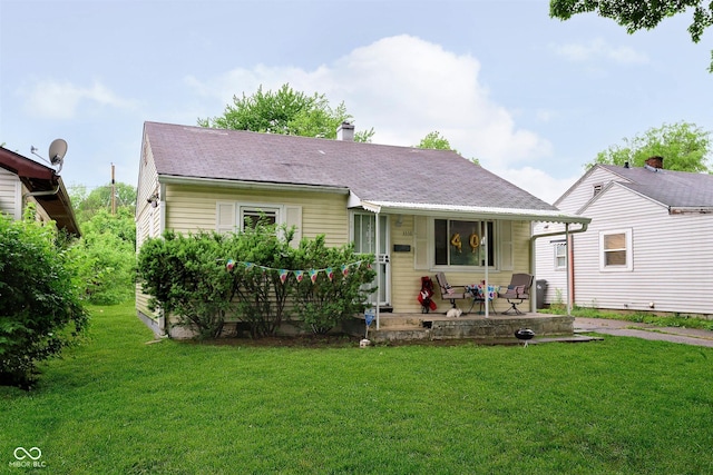 3338 Orchard Ave, Indianapolis, IN 46218 - view of front of property featuring a porch, a front yard, a chimney, and roof with shingles