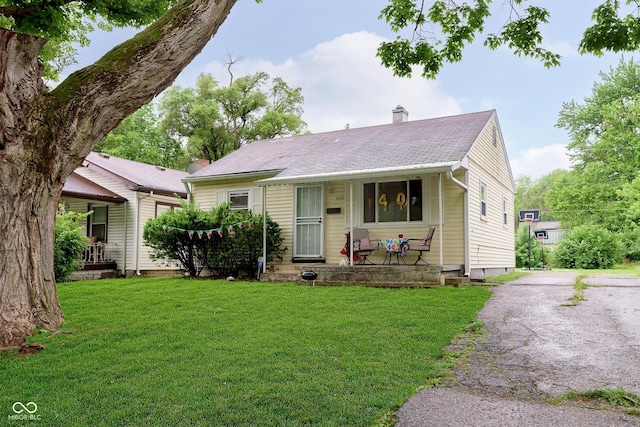3338 Orchard Ave, Indianapolis, IN 46218 - view of front of house featuring a porch, a front lawn, and a chimney