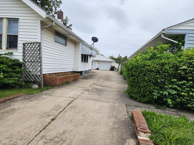 621 E 31st St, Anderson, IN 46016 - view of side of property with a chimney, a detached garage, and an outdoor structure