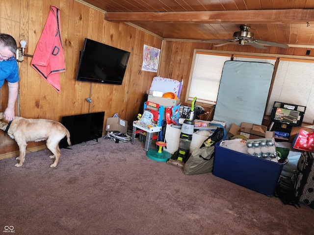 621 E 31st St, Anderson, IN 46016 - living room featuring wood ceiling with exposed beams, wooden walls, carpet flooring, and ceiling fan