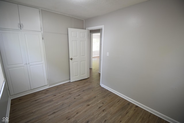 1902 N Colorado Ave, Indianapolis, IN 46218 - unfurnished bedroom featuring wood finished floors, a closet, and baseboards