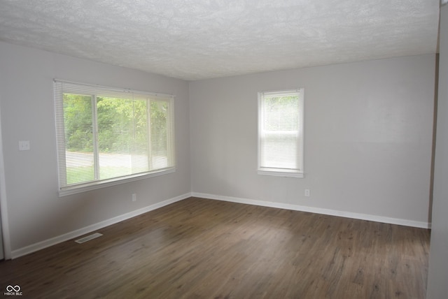 1902 N Colorado Ave, Indianapolis, IN 46218 - spare room with dark wood-type flooring, a textured ceiling, and baseboards