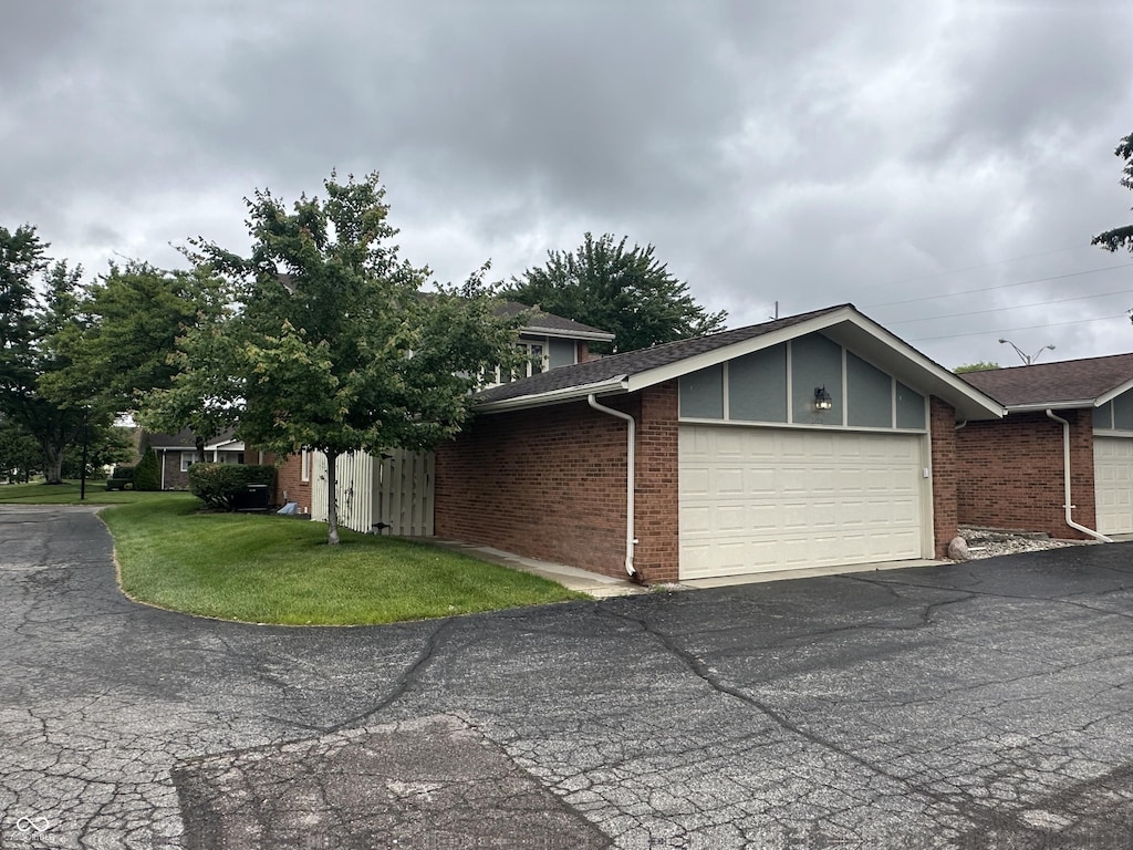 3975 Offshore Dr, Columbus, IN 47203 - view of front facade with a garage, brick siding, asphalt driveway, and a front yard