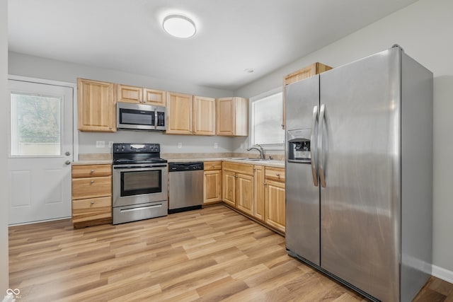 420 Vista Dr, Carmel, IN 46280 - kitchen with appliances with stainless steel finishes, light brown cabinets, light countertops, a sink, and light wood-style floors