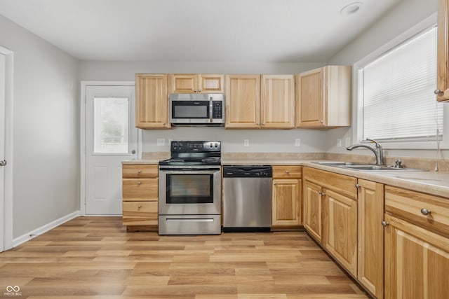 420 Vista Dr, Carmel, IN 46280 - kitchen featuring stainless steel appliances, a sink, light brown cabinets, light countertops, and light wood-style floors