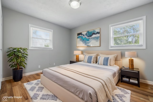 420 Vista Dr, Carmel, IN 46280 - bedroom with multiple windows, wood finished floors, and baseboards
