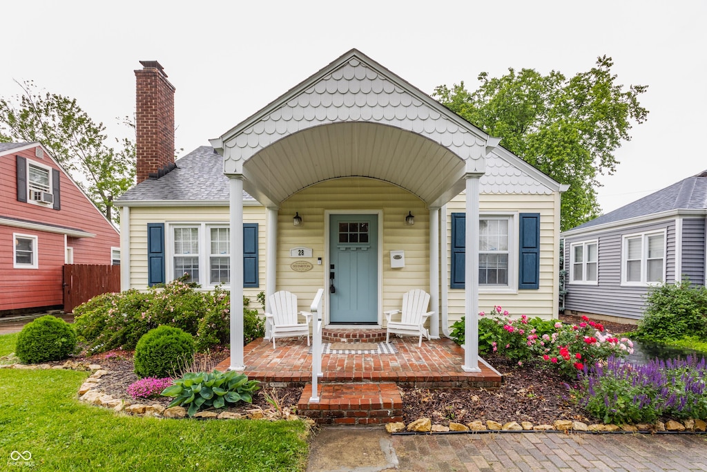 28 N Elizabeth St, Indianapolis, IN 46219 - view of front facade featuring covered porch and a chimney