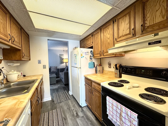 7445 Melanie Ln, Indianapolis, IN 46217 - kitchen with white appliances, under cabinet range hood, a sink, dark wood-style flooring, and brown cabinets