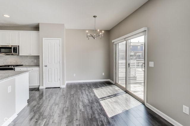 13050 Grand Vue Dr, Carmel, IN 46032 - unfurnished dining area featuring a chandelier, wood finished floors, and baseboards