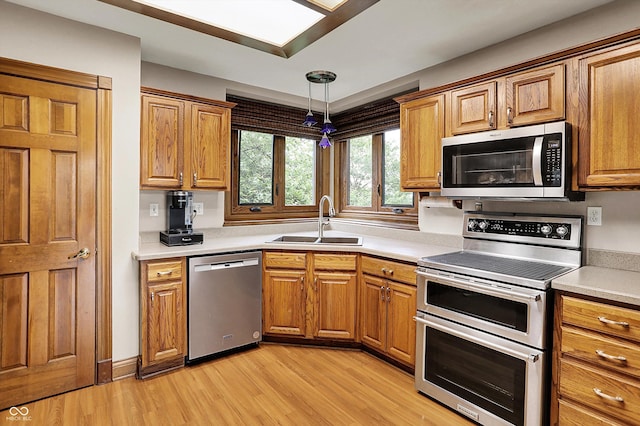 1850 Longest Dr, Franklin, IN 46131 - kitchen featuring stainless steel appliances, a sink, light wood finished floors, and brown cabinetry