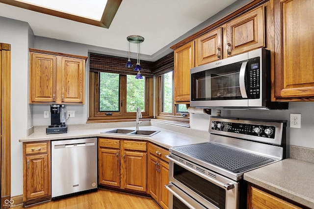 1850 Longest Dr, Franklin, IN 46131 - kitchen with stainless steel appliances, a sink, light wood-style floors, and brown cabinets