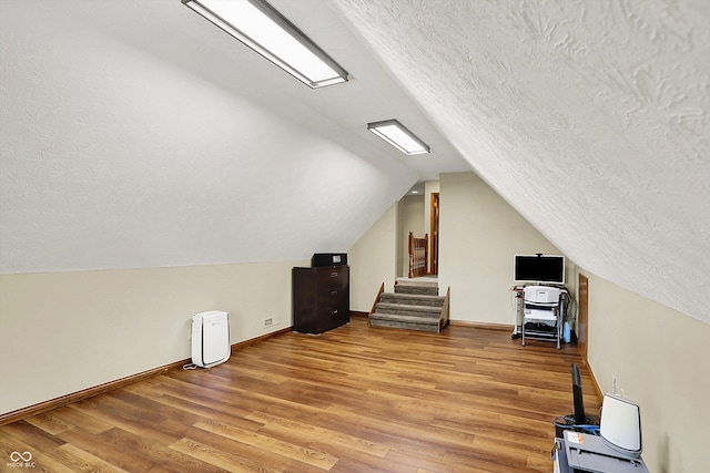 1850 Longest Dr, Franklin, IN 46131 - additional living space with a textured ceiling, vaulted ceiling, light wood-style floors, and baseboards