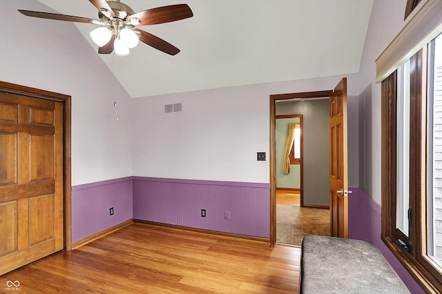 1850 Longest Dr, Franklin, IN 46131 - empty room with vaulted ceiling, light wood-style flooring, a wainscoted wall, and a ceiling fan