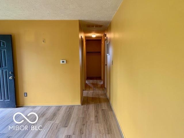 1998 Crescent St, Franklin, IN 46131 - hallway with a textured ceiling, wood finished floors, and baseboards