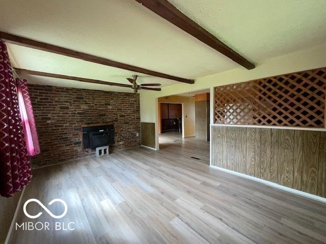 1998 Crescent St, Franklin, IN 46131 - unfurnished living room with wood finished floors, beamed ceiling, a ceiling fan, and baseboards